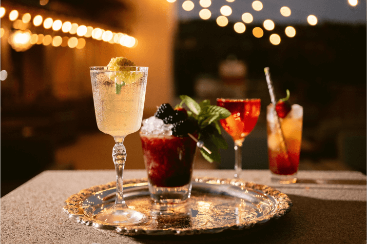 A tray with four different cocktails on a countertop.