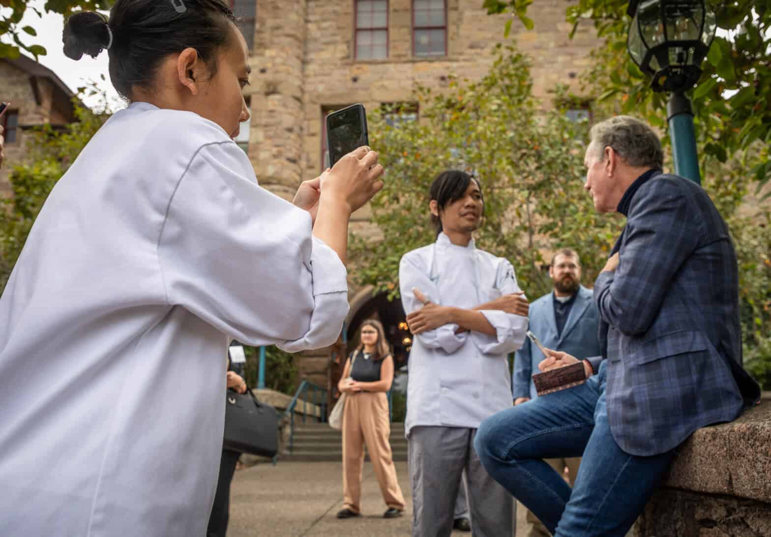 CIA students talking to someone visiting the CIA Greystone campus in the Napa Valley of California.