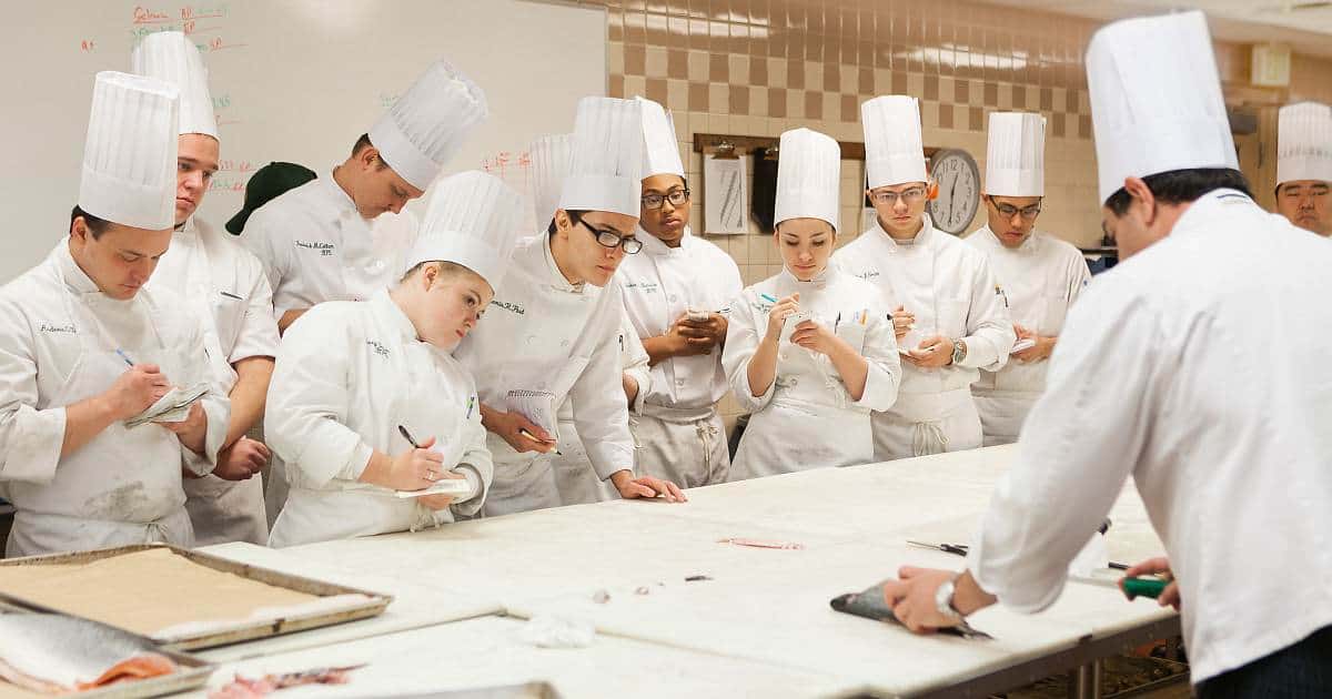 Is culinary school worth it? Students in a CIA classroom learning from an instructor.