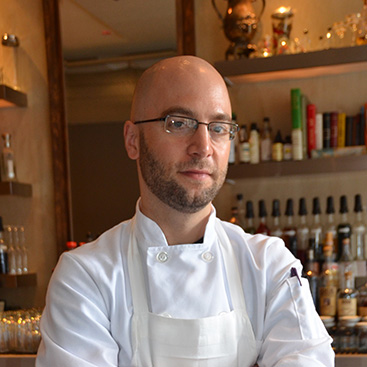 Image of Greg Vernick ’05 standing in a restaurant.